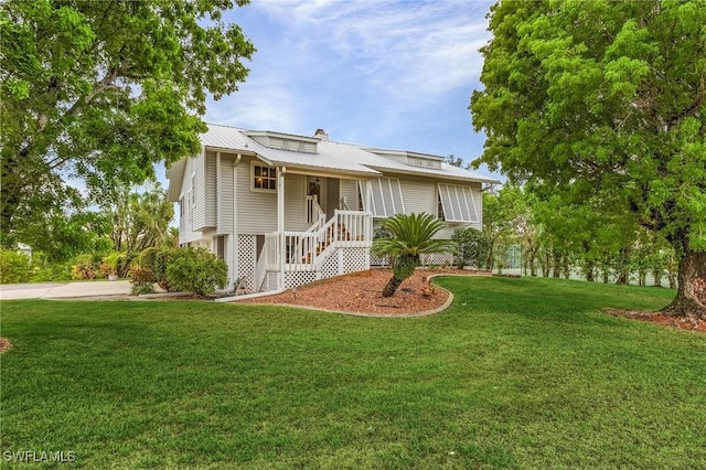 7269 Heaven Ln, Fort Myers, FL 33908 - view of front of property featuring a front lawn, metal roof, stairway, and a chimney