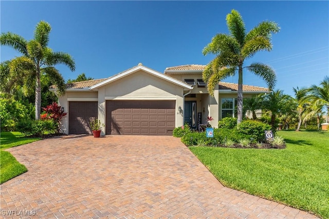 8651 Colony Trace Dr, Fort Myers, FL 33908 - mediterranean / spanish home featuring an attached garage, a front lawn, stucco siding, decorative driveway, and a tiled roof