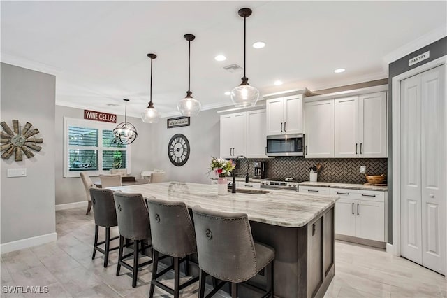 8651 Colony Trace Dr, Fort Myers, FL 33908 - kitchen with appliances with stainless steel finishes, a sink, crown molding, tasteful backsplash, and light stone countertops