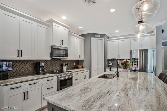 8651 Colony Trace Dr, Fort Myers, FL 33908 - kitchen featuring appliances with stainless steel finishes, a sink, backsplash, white cabinetry, and light stone counters