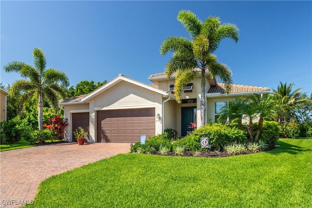 8651 Colony Trace Dr, Fort Myers, FL 33908 - mediterranean / spanish house featuring a front lawn, a garage, stucco siding, and decorative driveway
