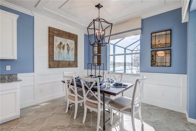 10871 Rose Quartz Ln, North Fort Myers, FL 33917 - dining room with crown molding, a decorative wall, a chandelier, a wainscoted wall, and a water view