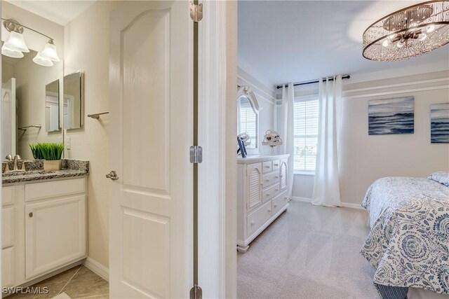 10871 Rose Quartz Ln, North Fort Myers, FL 33917 - bedroom featuring a sink, baseboards, a chandelier, and light colored carpet