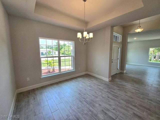 2201 Como St, Port Charlotte, FL 33948 - unfurnished room featuring a raised ceiling, wood finished floors, baseboards, and a chandelier