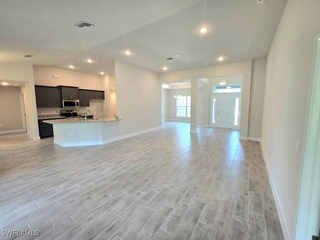 2201 Como St, Port Charlotte, FL 33948 - unfurnished living room with a sink, baseboards, light wood-style floors, and recessed lighting
