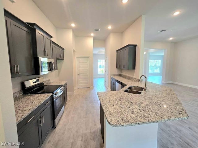 2201 Como St, Port Charlotte, FL 33948 - kitchen featuring appliances with stainless steel finishes, a sink, plenty of natural light, light stone counters, and recessed lighting