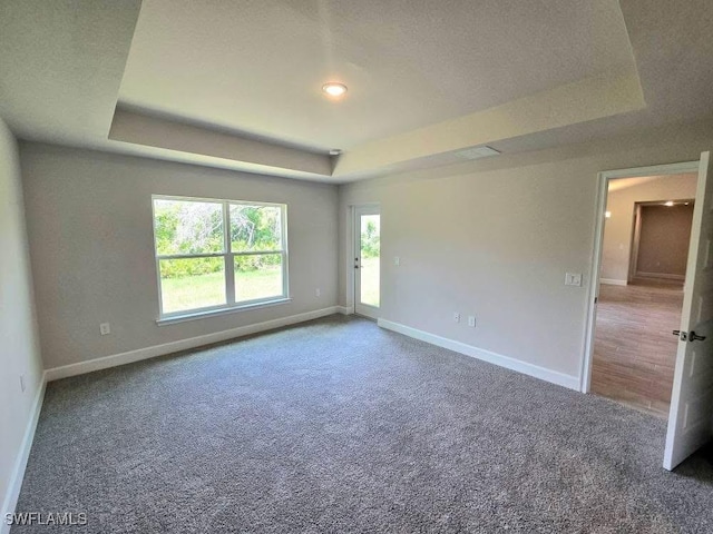 2201 Como St, Port Charlotte, FL 33948 - spare room with a raised ceiling, baseboards, and carpet floors