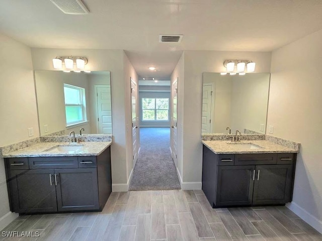 2201 Como St, Port Charlotte, FL 33948 - full bath featuring wood finish floors, baseboards, and two vanities