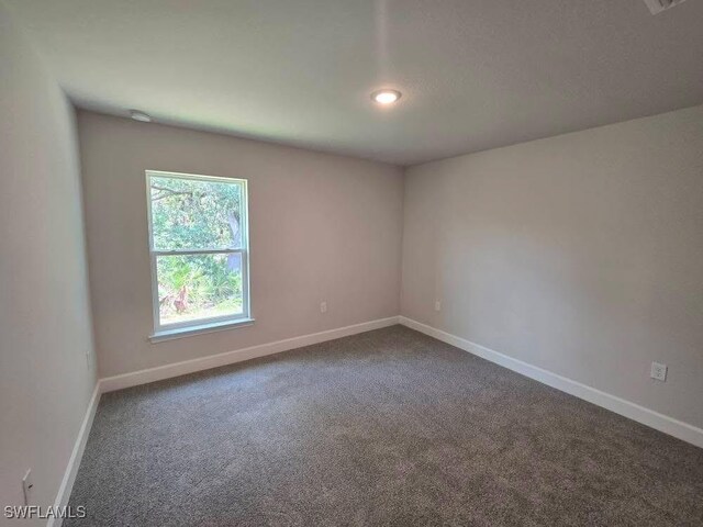 2201 Como St, Port Charlotte, FL 33948 - empty room with dark colored carpet, baseboards, recessed lighting, and a smoke detector
