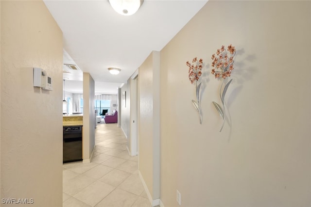 corridor with light tile patterned floors and baseboards