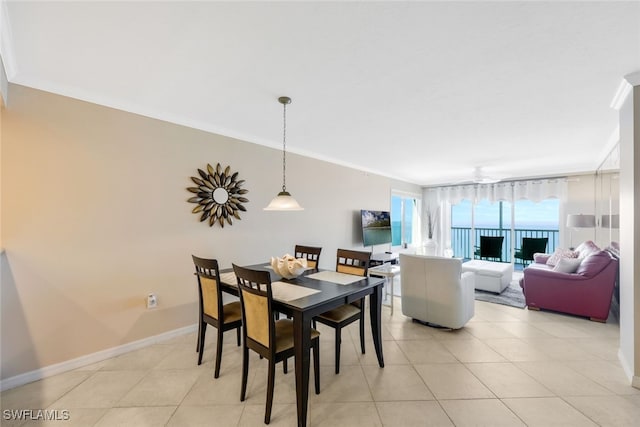 dining space featuring crown molding, light tile patterned floors, and baseboards