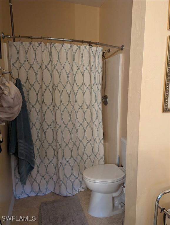 1711 NW 28th Ter, Cape Coral, FL 33993 - bathroom featuring a shower with shower curtain and tile patterned floors