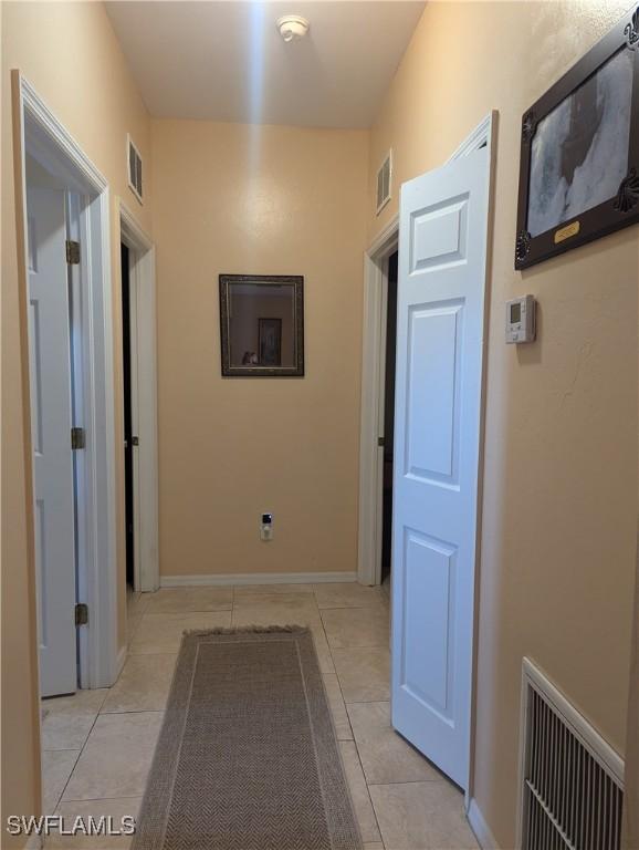 1711 NW 28th Ter, Cape Coral, FL 33993 - hallway with light tile patterned floors and baseboards