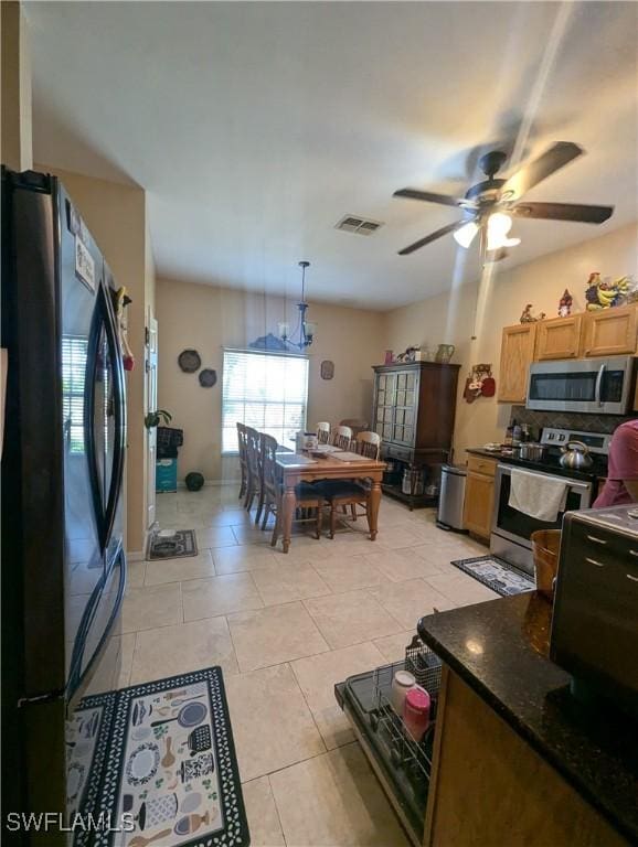 1711 NW 28th Ter, Cape Coral, FL 33993 - kitchen featuring stainless steel appliances, dark countertops, ceiling fan, and light tile patterned flooring