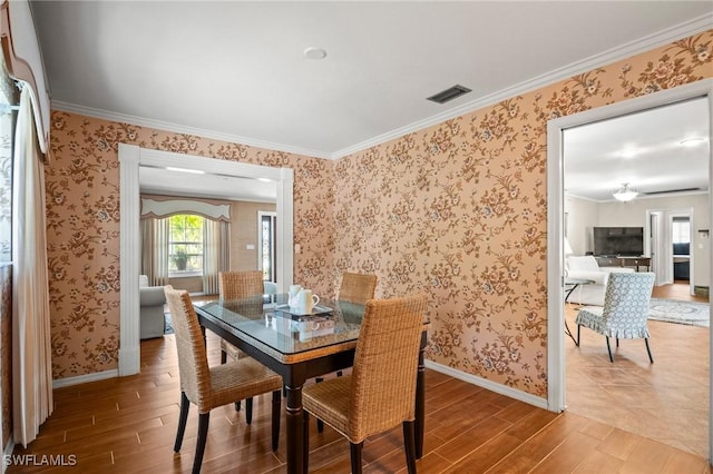 1263 Caloosa Dr, Fort Myers, FL 33901 - dining area with light wood-style flooring, baseboards, crown molding, and wallpapered walls