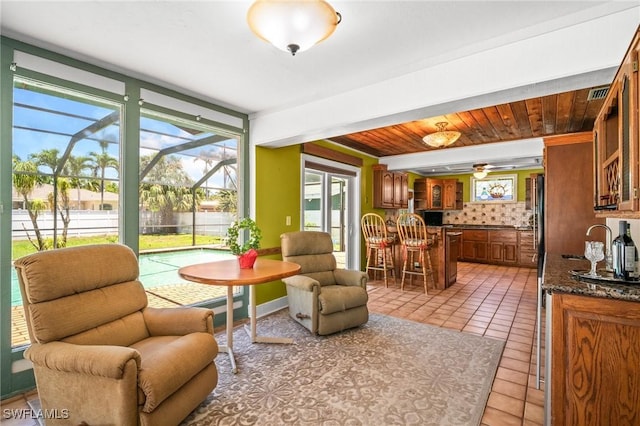 1263 Caloosa Dr, Fort Myers, FL 33901 - living area with light tile patterned floors, a sunroom, and a ceiling fan