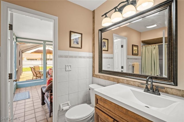 1263 Caloosa Dr, Fort Myers, FL 33901 - bathroom with vanity, tile walls, toilet, tile patterned floors, and wainscoting