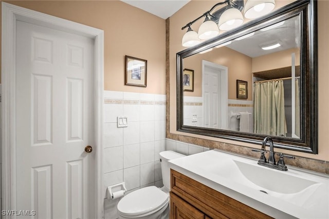 1263 Caloosa Dr, Fort Myers, FL 33901 - bathroom with tile walls, vanity, toilet, and a wainscoted wall