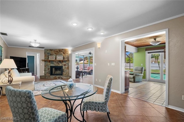 1263 Caloosa Dr, Fort Myers, FL 33901 - dining room featuring crown molding, plenty of natural light, tile patterned floors, baseboards, and a stone fireplace