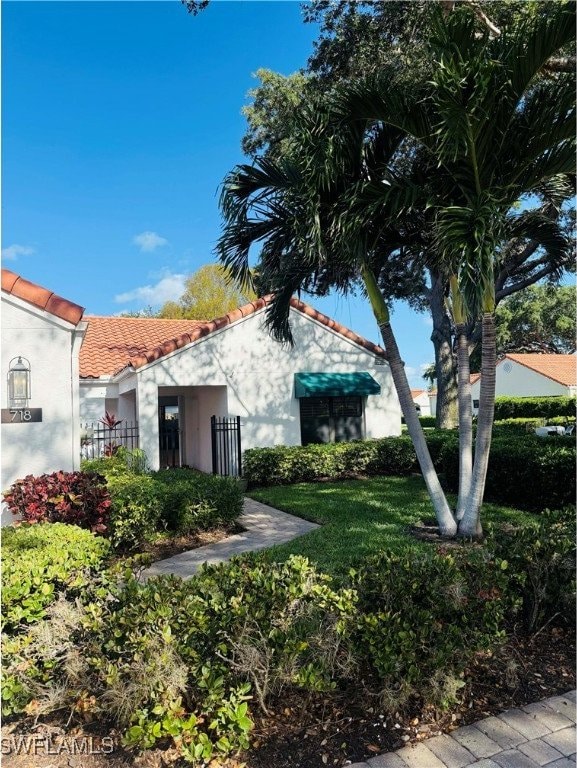 718 Reef Point Cir, Naples, FL 34108 - view of home's exterior featuring stucco siding and a tile roof