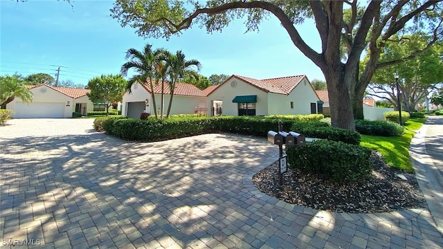 718 Reef Point Cir, Naples, FL 34108 - mediterranean / spanish home featuring a tile roof, stucco siding, and a garage