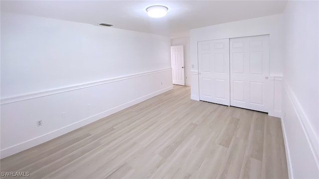 718 Reef Point Cir, Naples, FL 34108 - unfurnished bedroom with light wood-style floors, a closet, and baseboards