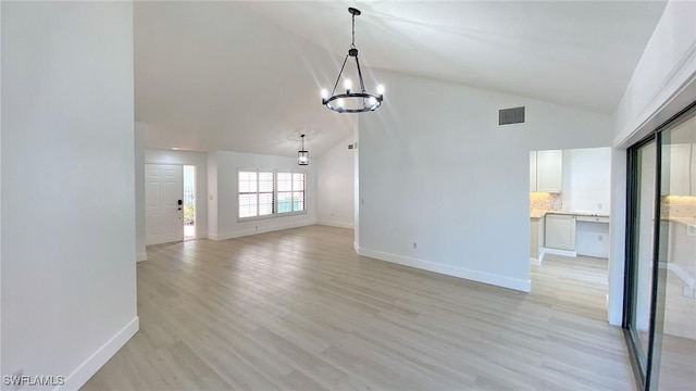 718 Reef Point Cir, Naples, FL 34108 - unfurnished living room with a chandelier, baseboards, light wood-style flooring, and high vaulted ceiling