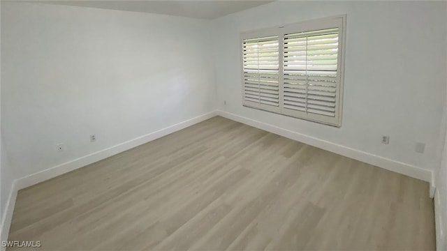 718 Reef Point Cir, Naples, FL 34108 - unfurnished room with baseboards and wood finished floors