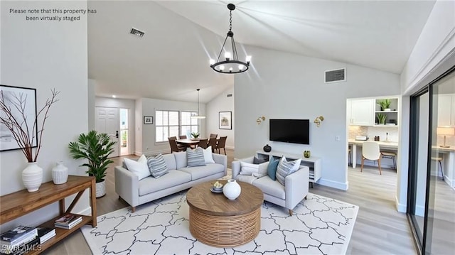 718 Reef Point Cir, Naples, FL 34108 - living room featuring a chandelier, light wood-type flooring, and high vaulted ceiling
