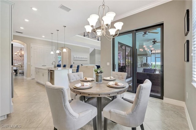 2102 Antigua Ln, Naples, FL 34120 - dining room featuring a chandelier, crown molding, arched walkways, baseboards, and light tile patterned floors