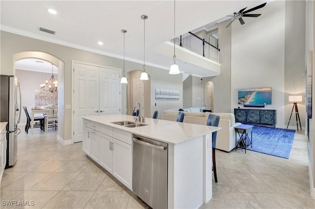 2102 Antigua Ln, Naples, FL 34120 - kitchen featuring a sink, stainless steel appliances, arched walkways, open floor plan, and crown molding