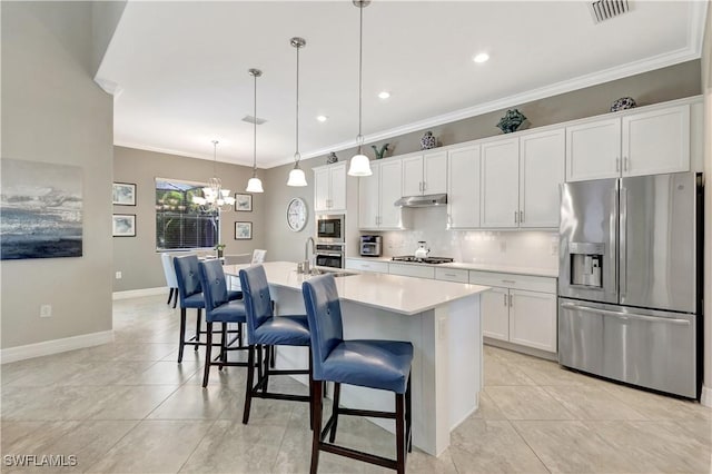 2102 Antigua Ln, Naples, FL 34120 - kitchen with appliances with stainless steel finishes, tasteful backsplash, white cabinets, a chandelier, and an island with sink