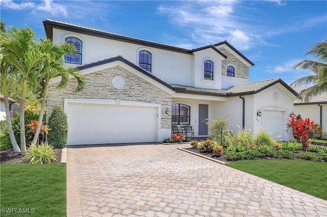 2102 Antigua Ln, Naples, FL 34120 - view of front facade with stucco siding, decorative driveway, stone siding, and a garage