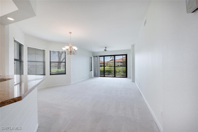 unfurnished living room with a chandelier, baseboards, and light colored carpet