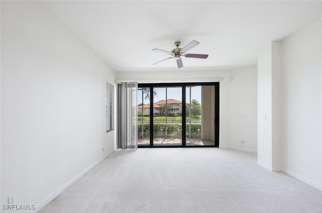 spare room with baseboards, carpet flooring, and a ceiling fan