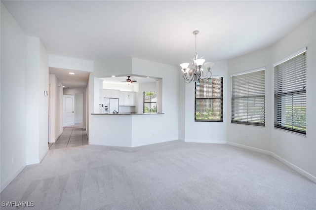 unfurnished living room with light colored carpet, a chandelier, plenty of natural light, ceiling fan, and recessed lighting