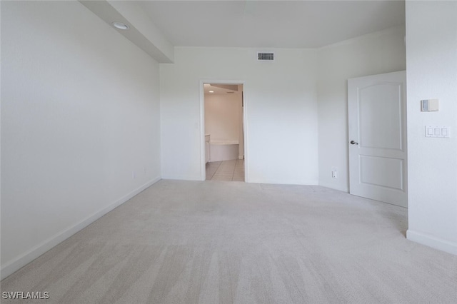spare room featuring carpet and baseboards
