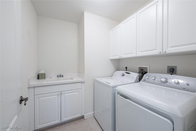 laundry area with cabinet space, washer and dryer, and light tile patterned floors