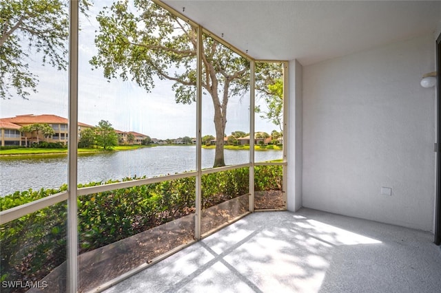 unfurnished sunroom featuring a water view