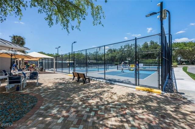 view of tennis court with fence and a gate