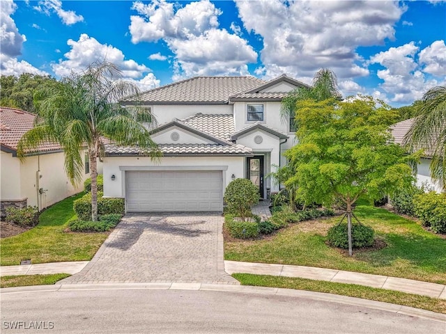 11937 Silver Cobblestone Way, Fort Myers, FL 33913 - view of front facade with an attached garage, driveway, stucco siding, a tiled roof, and a front lawn