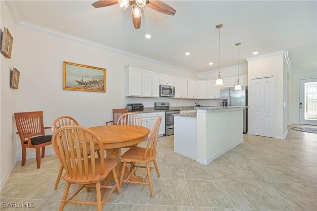 11937 Silver Cobblestone Way, Fort Myers, FL 33913 - kitchen featuring appliances with stainless steel finishes, ornamental molding, white cabinets, a ceiling fan, and decorative light fixtures