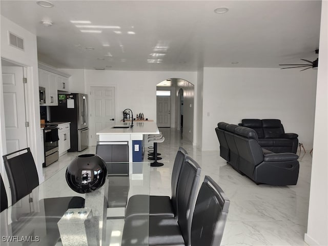 2709 SW 4th Pl, Cape Coral, FL 33914 - dining area with arched walkways, light marble finish flooring, and ceiling fan