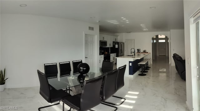 2709 SW 4th Pl, Cape Coral, FL 33914 - dining area featuring arched walkways and light marble finish flooring