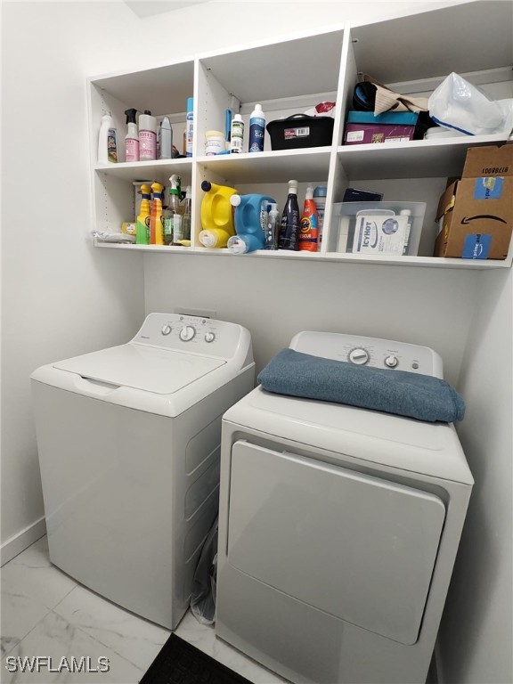 2709 SW 4th Pl, Cape Coral, FL 33914 - washroom with washing machine and clothes dryer and marble look tile flooring