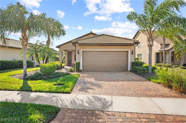 10947 Clarendon St, Fort Myers, FL 33913 - view of front of property with a garage, decorative driveway, stucco siding, and a tiled roof
