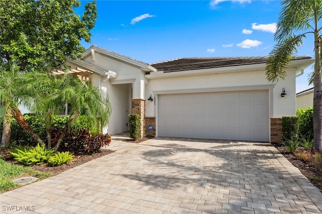 16523 Crescent Beach Way, Bonita Springs, FL 34135 - view of front of home with stone siding, stucco siding, and driveway