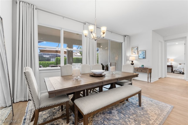 16523 Crescent Beach Way, Bonita Springs, FL 34135 - dining room with a chandelier, light wood-type flooring, and baseboards