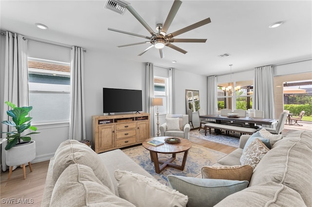 16523 Crescent Beach Way, Bonita Springs, FL 34135 - living area with a chandelier, light wood-style flooring, ceiling fan, and baseboards