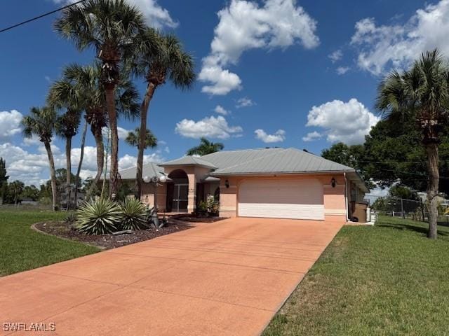 1200 Elaine Ave N, Lehigh Acres, FL 33971 - ranch-style house with a front yard, an attached garage, concrete driveway, and stucco siding
